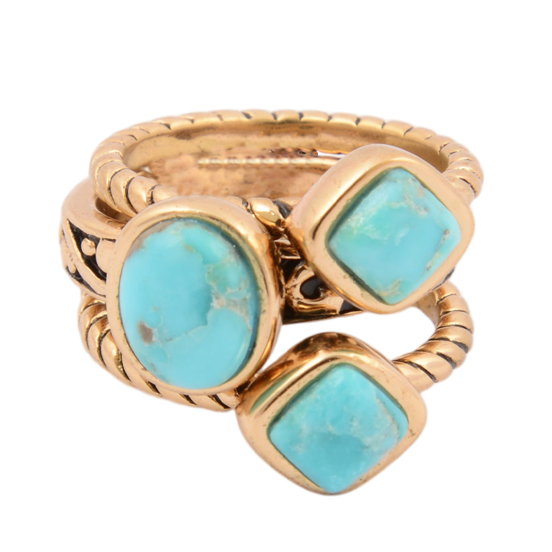 Gold ring with turquoise stones on a white background