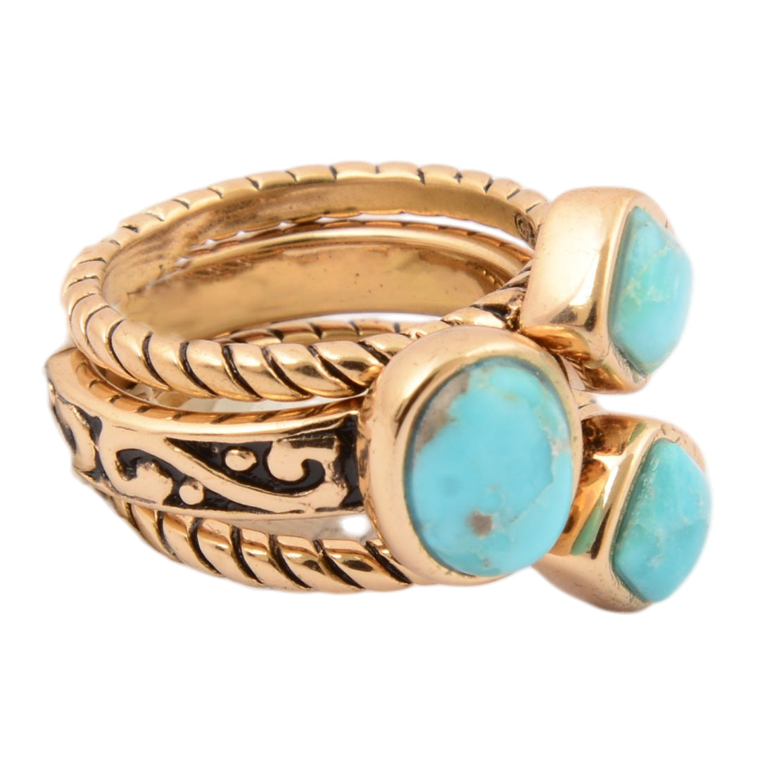 Set of gold and turquoise rings on a white background