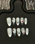 Set of nail art designs on a black stand with a patterned background