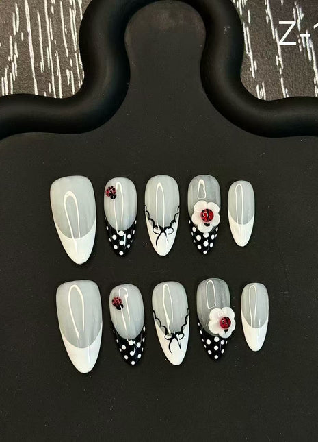Set of nail art designs on a black stand with a patterned background