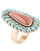 Ring with turquoise stones and a central brown stone on a white background
