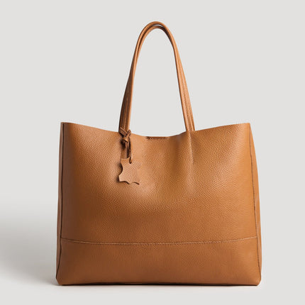 Brown leather tote bag on a light gray background