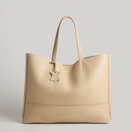 Beige handbag with a visible brand logo on a light gray background