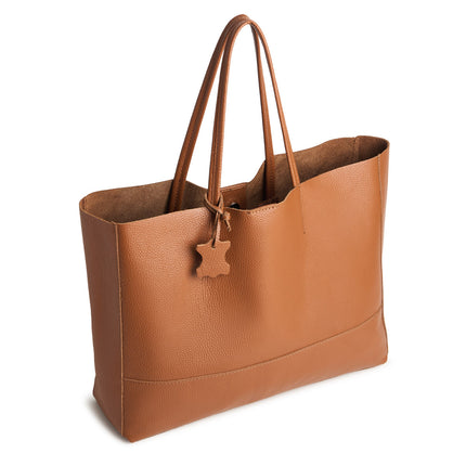 Brown leather tote bag with a star-shaped tag on a white background